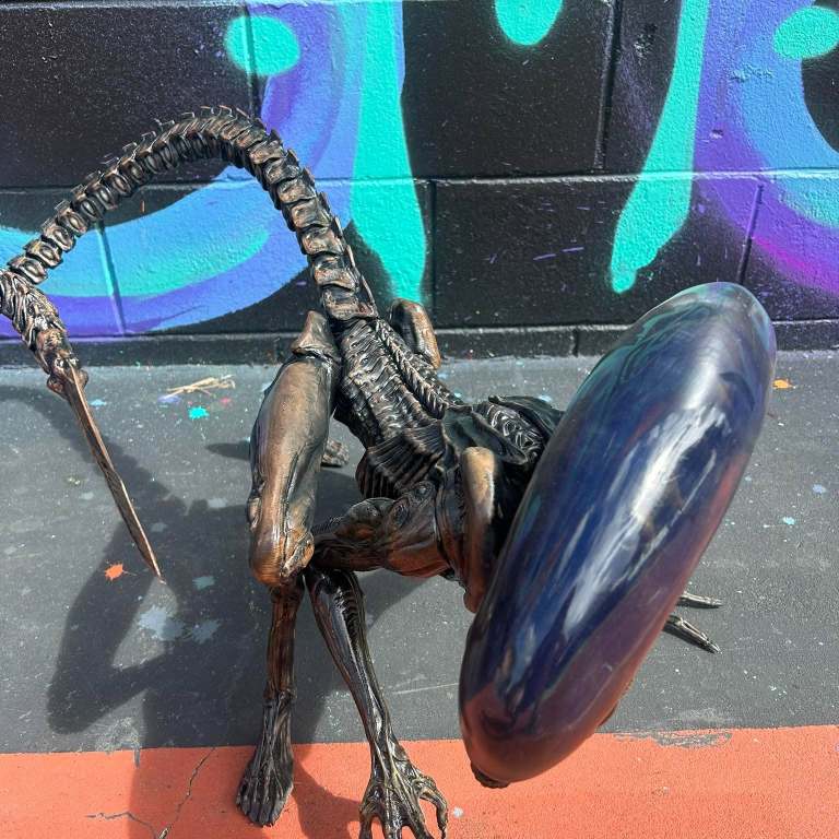 Close-up of a bronze-finish 3D printed xenomorph sculpture